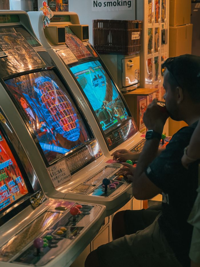Vintage arcade gaming experience with a man playing retro video games in a classic gaming room.