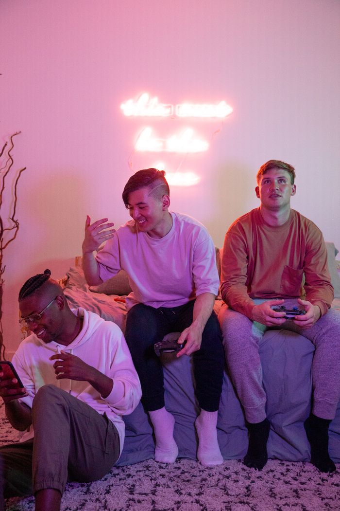 services-02 Group of young men having fun playing video games under neon lights.